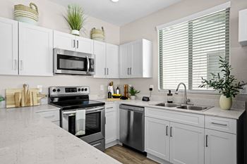 A modern kitchen with white cabinets and stainless steel appliances